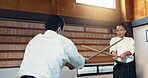 Asian man, taekwondo and training with wooden sticks for martial arts, fighting or sparring partner in dojo. People in fight practice with dummy weapon to opponent in karate for self defense at gym