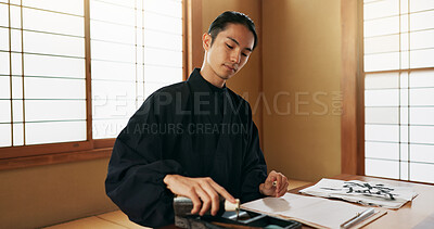 Black ink, Asian man or Japanese artist in studio for art and script, calligraphy with paper for alphabet. Start, ready or creative person with tools, paintbrush and focus with traditional stationery