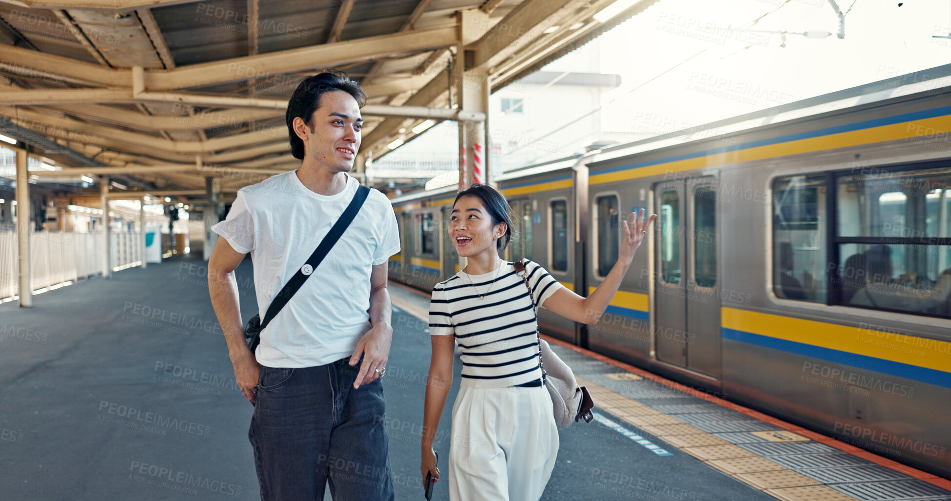 Buy stock photo Walking, conversation and young couple by train station for exploring on vacation or holiday. Travel, happy and Asian man and woman talking by public transport for adventure together on weekend trip.