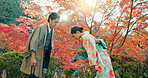 People in park in Japan, bow and traditional clothes with hello, nature and sunshine with respect and culture. Couple outdoor together in garden, greeting with modesty and tradition, polite and kind