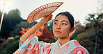 Fan, thinking or calm Asian woman in park for journey on holiday vacation for freedom or wellness. Nature, travel or Japanese person with ideas for health, peace and inspiration to relax in forest