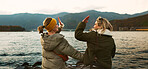 Women friends, hug and back at beach with care, love and outdoor with high five, support or celebration on travel. Girl, cheers and achievement with boat, water or lake with bonding by river in Japan