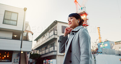 Woman, Asian and walking on sidewalk, travel or commute to work with professional in city with earphones. Listening to music on journey, podcast and commuter on urban street in Tokyo with playlist