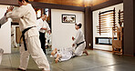 Students, aikido or learning Japanese martial arts in dojo for practice, body movement or self defense. Combat demonstration, group of people or training workout for fighting, education or class