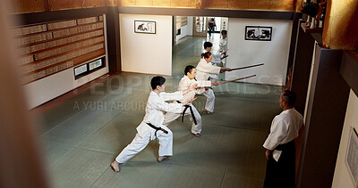 Buy stock photo Aikido students, stick or learning martial arts in dojo for practice, movement or self defense. Combat demonstration, above or Japanese people in training workout for fighting, education or sensei
