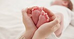 Feet, hands and mother with baby, love and support for care, health and wellness in bedroom. Closeup, family or mama with an infant, protection and child development with bonding or maternity in home