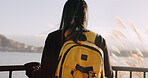 Woman, water and backpack with back, thinking and mountains on adventure, trip or vacation in nature. Girl, person and ideas on holiday with bag, vision and memory by lake, river and bridge in Tokyo