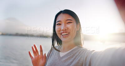 Japanese woman, selfie and happy outdoor, pointing at lake or river for social media and travel influencer in nature. Live streaming, adventure and wave at camera in Japan with smile in portrait