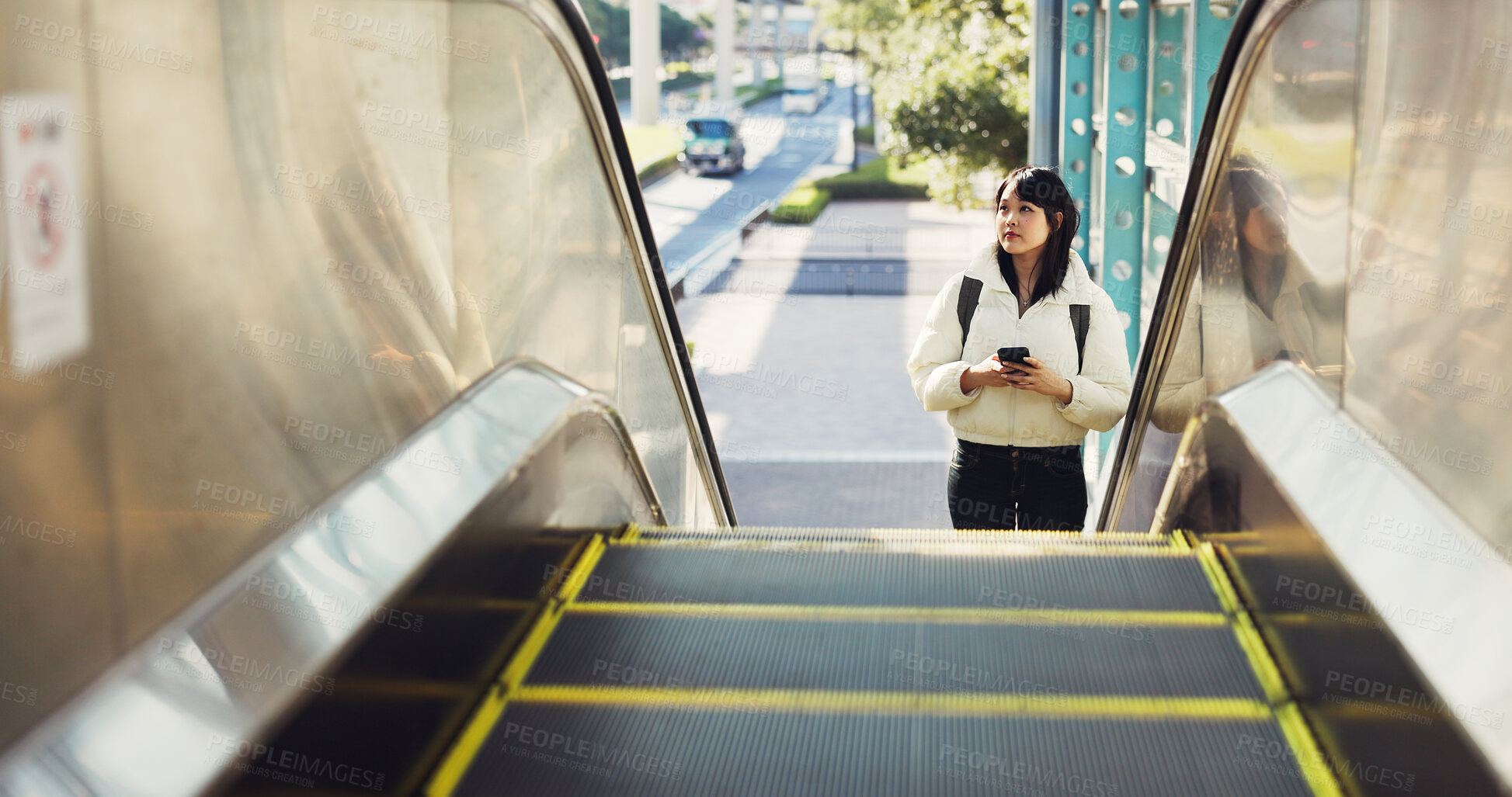 Buy stock photo Woman, stairs and smartphone for commute, texting and japanese on social media app. Technology, communication and text message for digital, internet and chatting with backpack, travel and escaltor