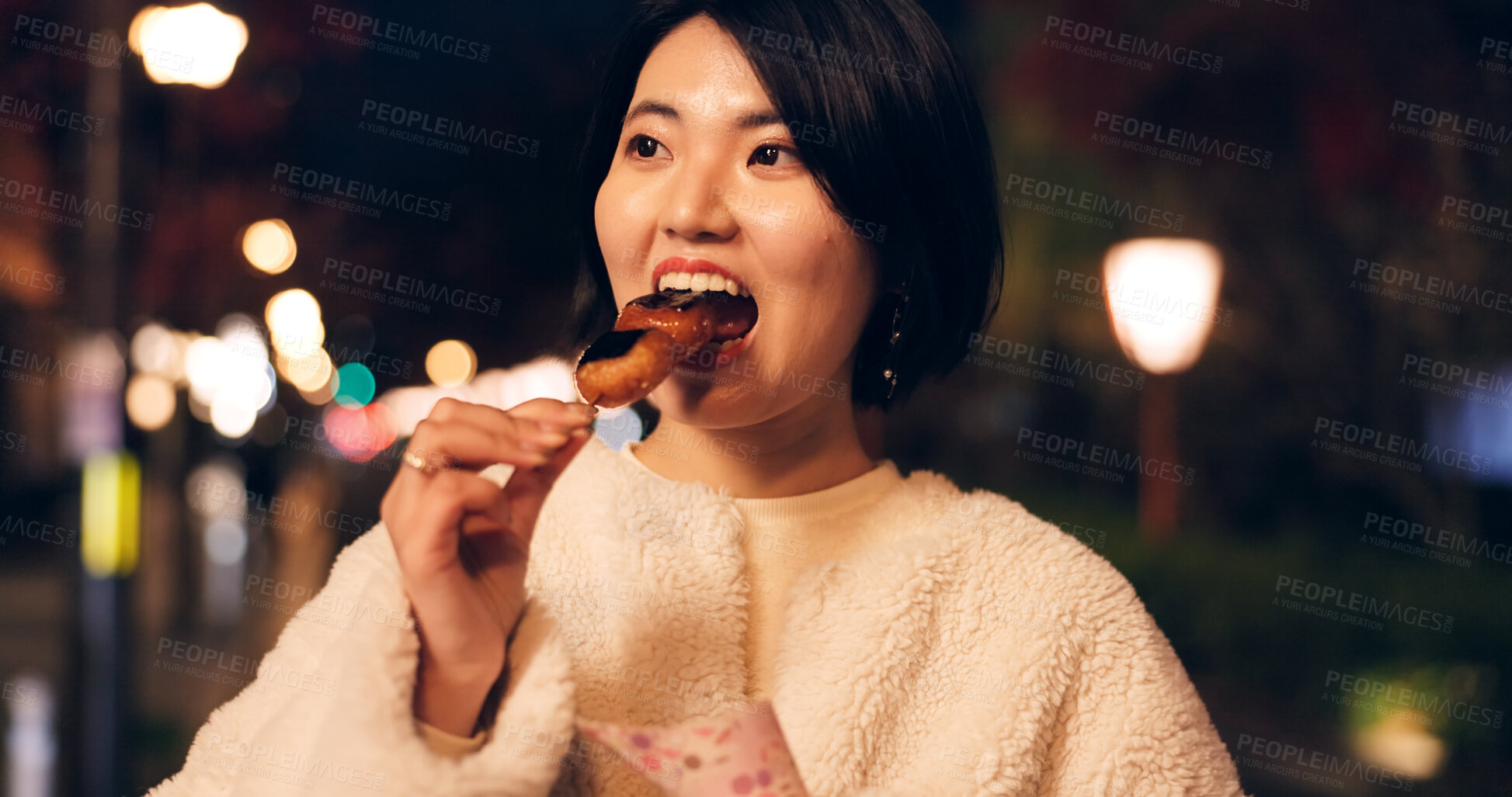 Buy stock photo Woman, street food and eating Japanese snack for travel experience, hungry or local trip. Female person, sidewalk and night or bite grilled mochi on road for vacation culture, adventure or tradition