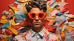 Man in suit, sunglasses, surrounded by colorful background shapes and confetti. Dapper, confident and festive individual exuding style, vibrancy and celebration in a dynamic visual display.