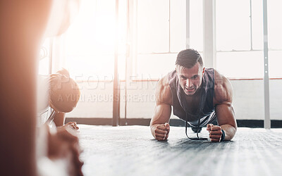 Buy stock photo Shot of a determined young man doing pushups at the gym