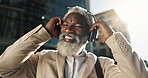 Happy, dancing and senior businessman with headphones in the city walking and listening to music. Smile, happy and elderly African male person streaming playlist, song or radio commuting in town.