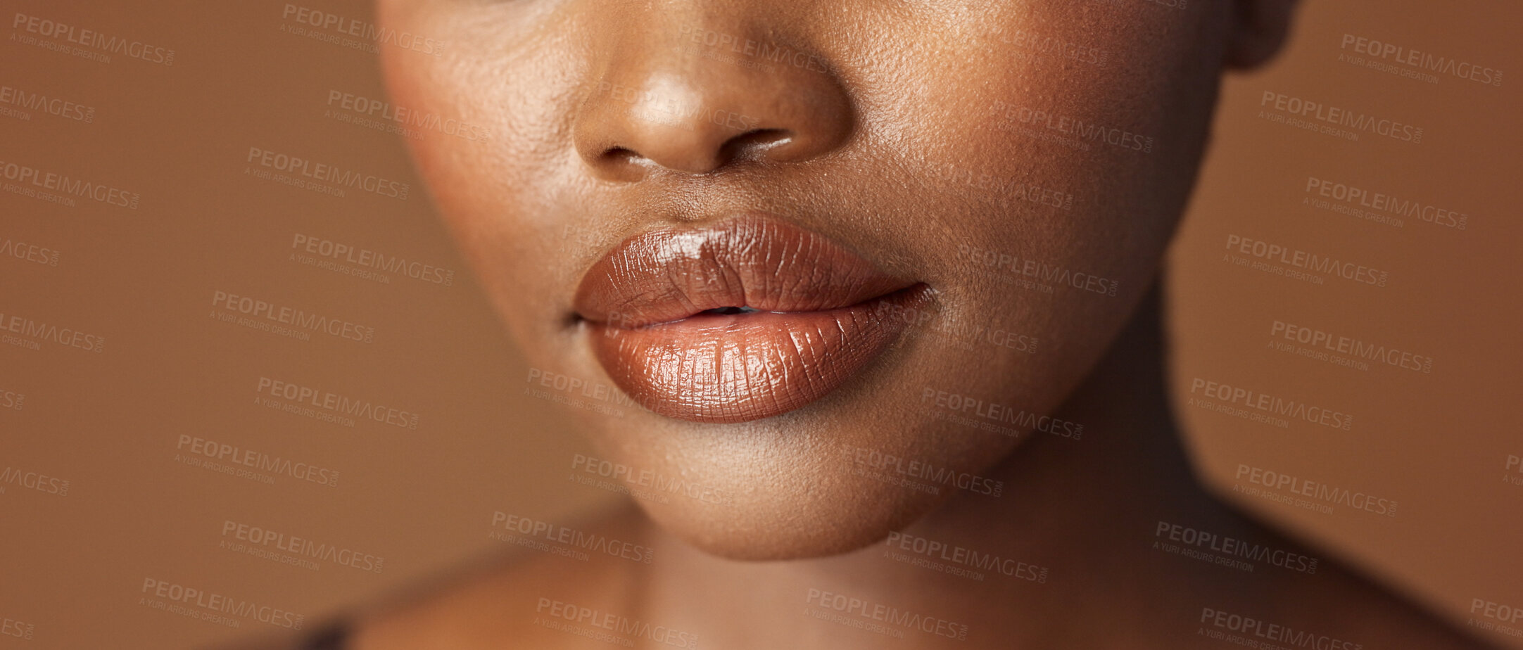 Buy stock photo Closeup, lips and black woman with beauty, smile and skincare on a brown studio background. African person, girl and model with gloss, cosmetics and dermatology with clear skin, smooth and aesthetic