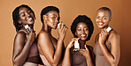 Happy black woman, skincare and cosmetics for beauty, tone or foundation against a brown studio background. Group portrait of African female people or model smile together with skin makeup on mockup