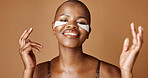 Face, beauty or happy black woman with eye patch for skincare or wellness isolated on brown background. Studio, smile or model with facial collagen pads, dermatology product or anti aging cosmetics