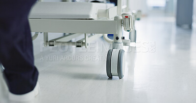 Healthcare, doctor and push bed in hospital for surgery, emergency or medical problem in corridor. Medicine, professional and nurse feet with stretcher for wellness, service and risk in clinic or job