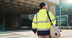 Man, back and architect walking in city for construction, maintenance or building at outdoor site. Rear view of male person, engineer or contractor carrying bag for project, architecture or plan