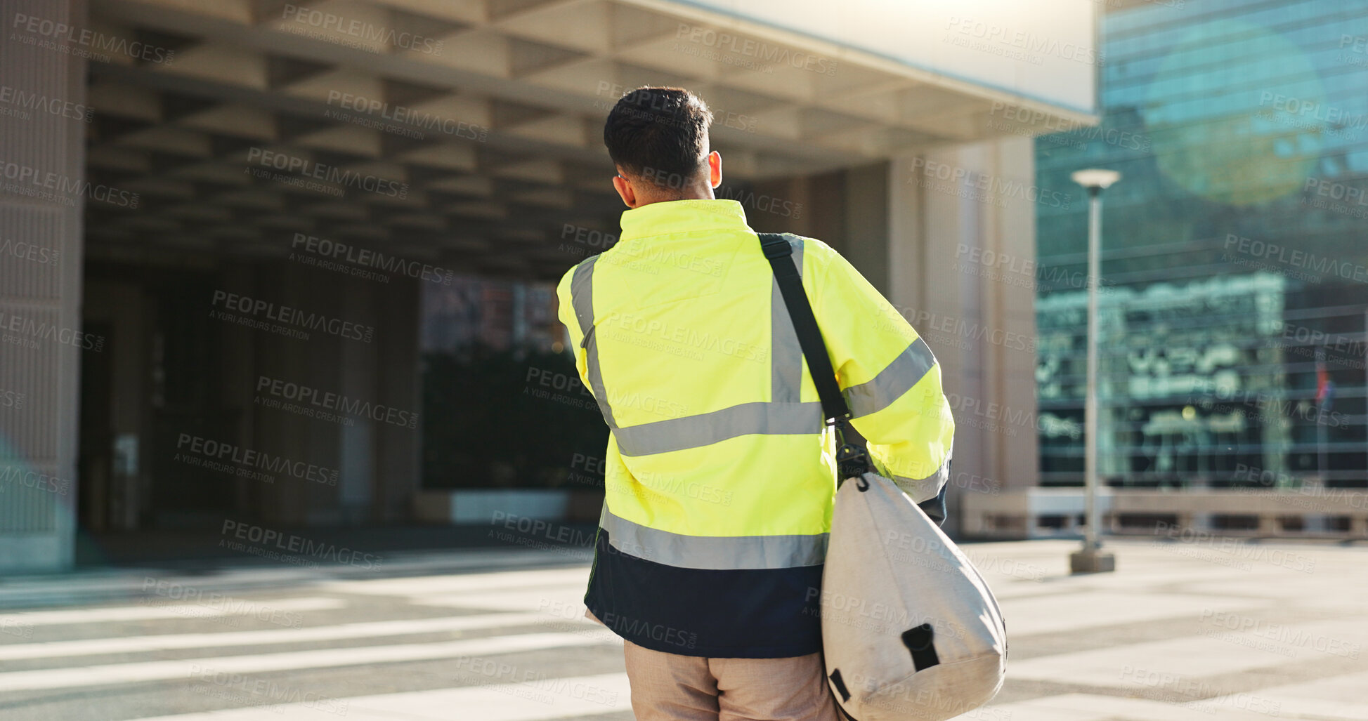 Buy stock photo Man, back and architect walking in city for construction, maintenance or building at outdoor site. Rear view of male person, engineer or contractor carrying bag for project, architecture or plan