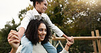 Mother, daughter and piggyback walking in park or garden for fun bonding, holiday or weekend outside. Happy mom carrying her child on shoulders for family time together in nature or forest by house