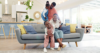 Happiness, playful parents and kids on sofa, black family having fun and smile in home together. Mother, father and young children playing on couch in living room, happy playing with love and support