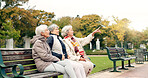 Happy, senior friends and walking together on an outdoor path or relax in nature with elderly women in retirement. People, talking and sitting for conversation on a park bench in autumn or winter