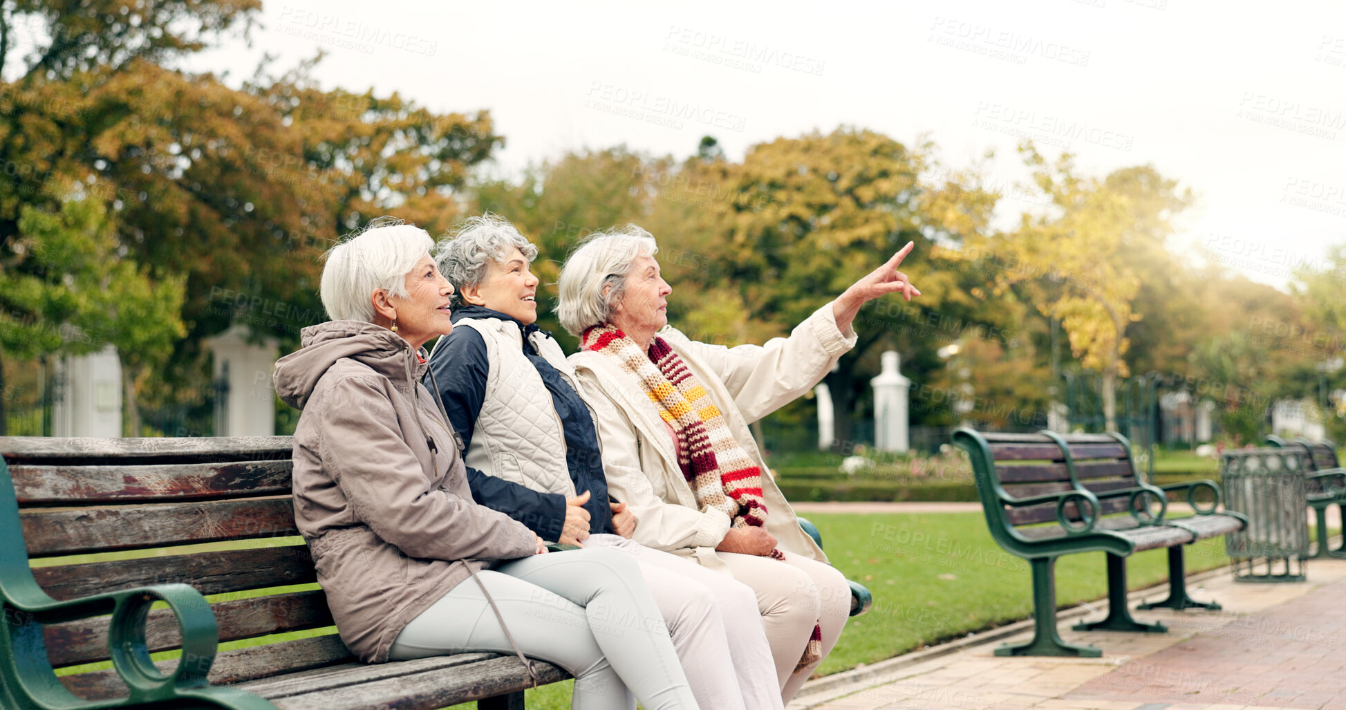 Buy stock photo Happy, senior friends and walking together on an outdoor path or relax in nature with elderly women in retirement. People, talking and sitting for conversation on a park bench in autumn or winter