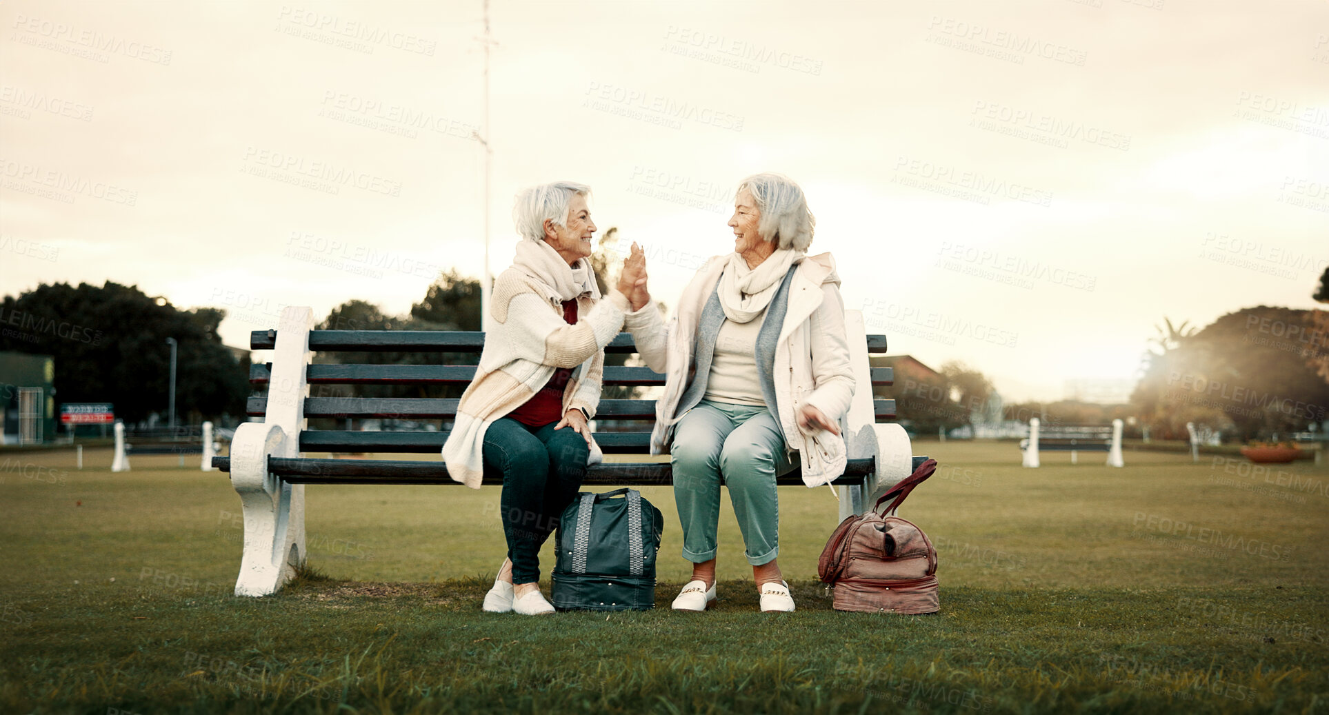 Buy stock photo Relax, high five and friends with old women on park bench for freedom, support and health. Retirement, happiness and celebration with senior people walking in outdoors for wellness, peace and calm