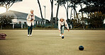 Women, park or old people bowling for fitness, training or exercise for wellness or teamwork outdoors. Senior ladies, relax or elderly friends playing fun ball game or sport in workout together