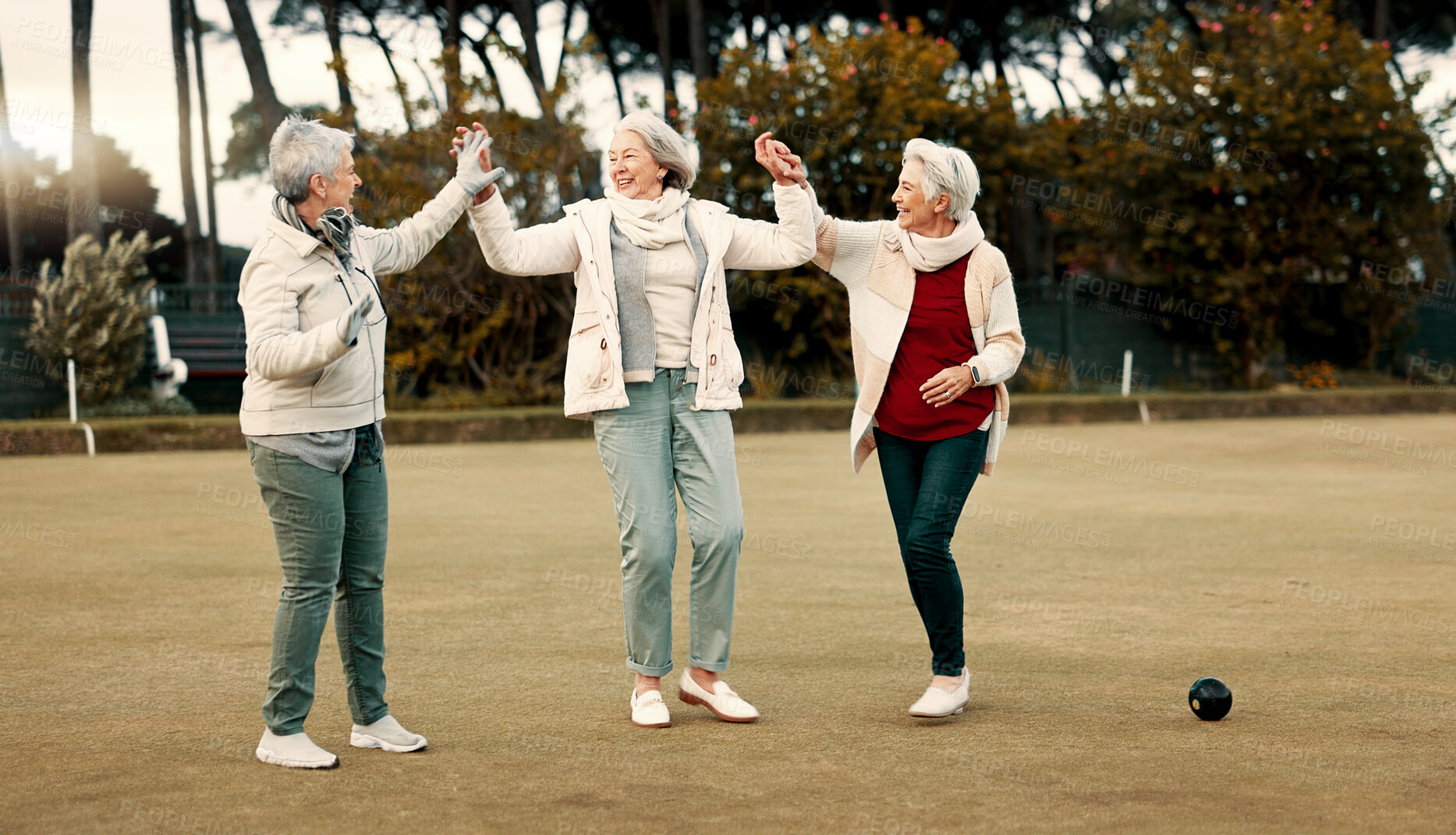 Buy stock photo Senior women, celebration and park for sport, lawn bowling and happy for fitness, goal or applause in nature. Teamwork, elderly lady friends and metal ball for games, contest or win together on grass