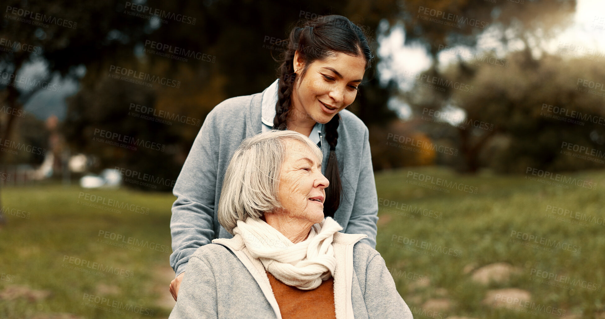 Buy stock photo Senior woman, talking and outdoor with caregiver, nurse or healthcare service for person with a disability and wheelchair. Happy, face and elderly lady in park with care and support in retirement