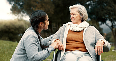 Caregiver helping woman with disability in park for support, trust and care in retirement. Nurse talking to happy senior patient in wheelchair for rehabilitation, therapy and conversation in garden