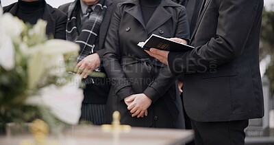 Bible, hands and family at funeral, cemetery or burial ceremony religion by coffin tomb. Holy book, death and grief of people at graveyard, Christian priest reading spiritual gospel and faith in God