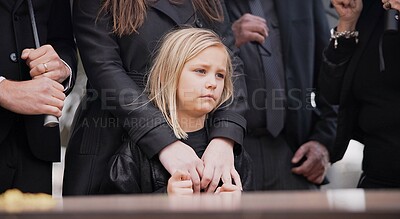 Child, sad and family at funeral at graveyard ceremony outdoor at burial place. Death, grief and group of people with casket or coffin at cemetery for service while mourning a loss at event or grave