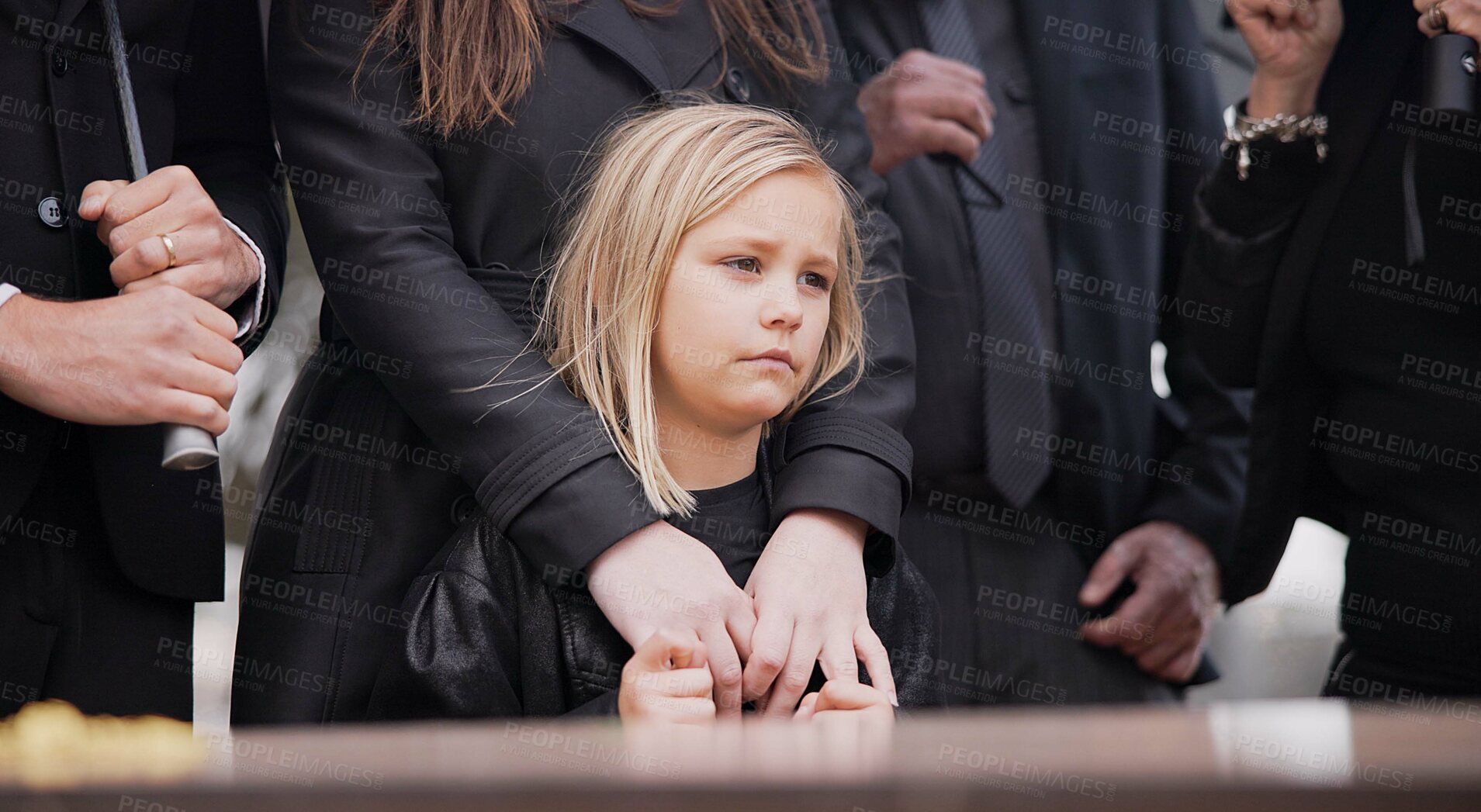 Buy stock photo Child, sad and family at funeral at graveyard ceremony outdoor at burial place. Death, grief and group of people with casket or coffin at cemetery for service while mourning a loss at event or grave