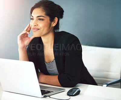 Buy stock photo Cropped shot of an attractive young businesswoman looking thoughtful working on a laptop in her office