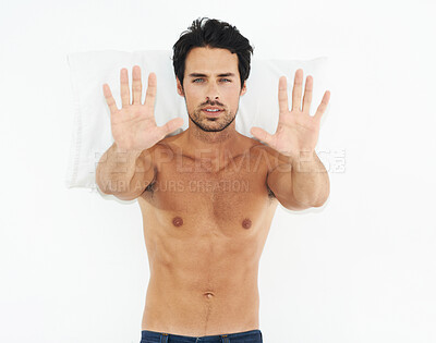 Buy stock photo Portrait, stop and palms of a man on his bed in studio isolated on a white background for rejection. Face, hand gesture and pillow with the body of a shirtless young model in the bedroom of his home