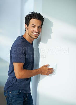 Buy stock photo Man, wall and light switch in home bedroom or portrait smile for weekend, calm peace of holiday vacation. Male person, face and press for power electricity in residential apartment, flick or control