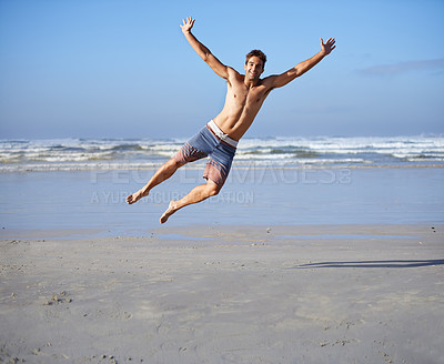 Man, jumping and portrait for happiness at beach, outdoor fun and happy in summer on vacation. Young person, playing and leisure on holiday by sea, freedom and energy for travel adventure by waves