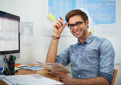 Buy stock photo A young travel agent looking at a brochure