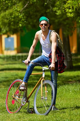 Buy stock photo Bicycle, park and portrait of young man for travel, journey and carbon footprint, streetwear and cool fashion at university. Person or college student in sunglasses, bike transport and outdoor campus