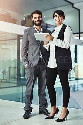 Buy stock photo Portrait of two colleagues working together on a digital tablet in a modern office