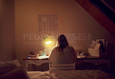 Buy stock photo Rearview shot of a young woman using her laptop in her bedroom at night