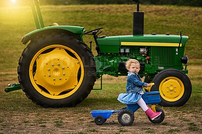 Buy stock photo Portrait of an adorable little girl riding a toy truck on a farm