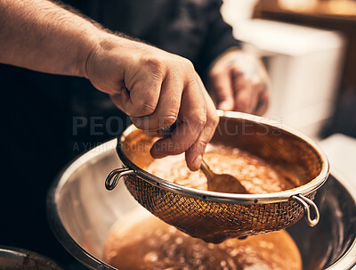 Buy stock photo Closeup of a unrecognisable chef's tattooed hands straining food into a bowl in kitchen of a restaurant