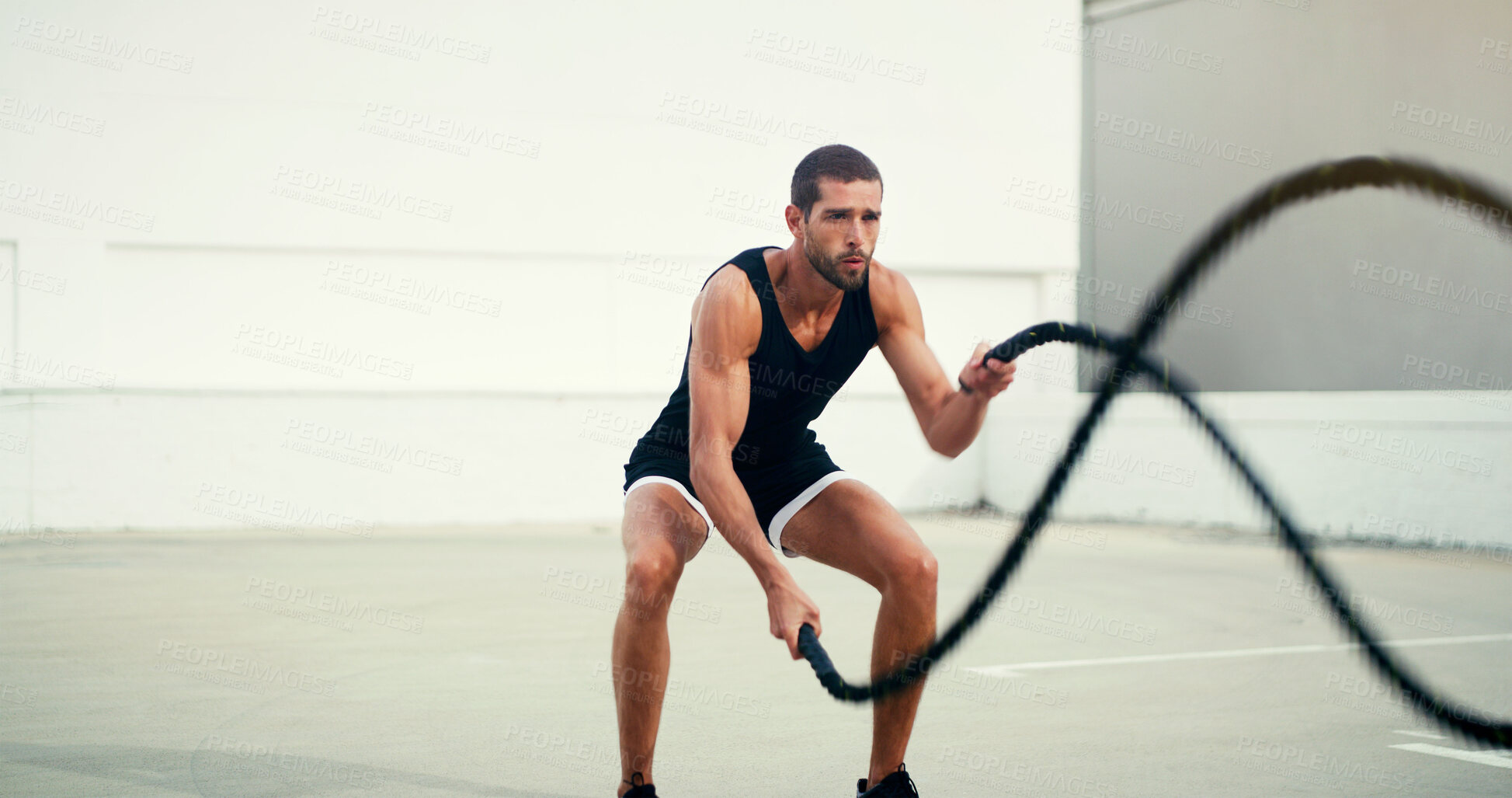 Buy stock photo Man, fitness and battle rope training for physical exercise, workout or wellness in the outdoors. Fit, active and serious male person exercising with ropes for intense endurance, stamina or cardio