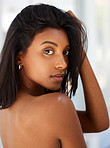 Portrait, beauty and confidence with an indian woman in her home, feeling beautiful or sensual. Face, hair and relax with an attractive young female in her apartment looking confident or feminine