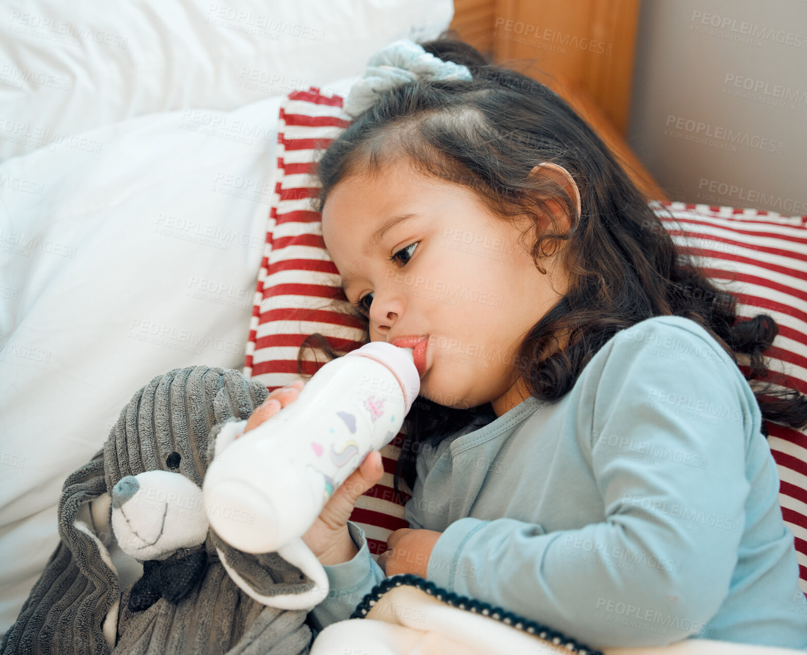 Buy stock photo Home, milk and bottle for little girl to drink, enjoy and rest on bed of bedroom in apartment. Toddler, calm and feeding on formula for nutrition, growth and development of child in nursery of house