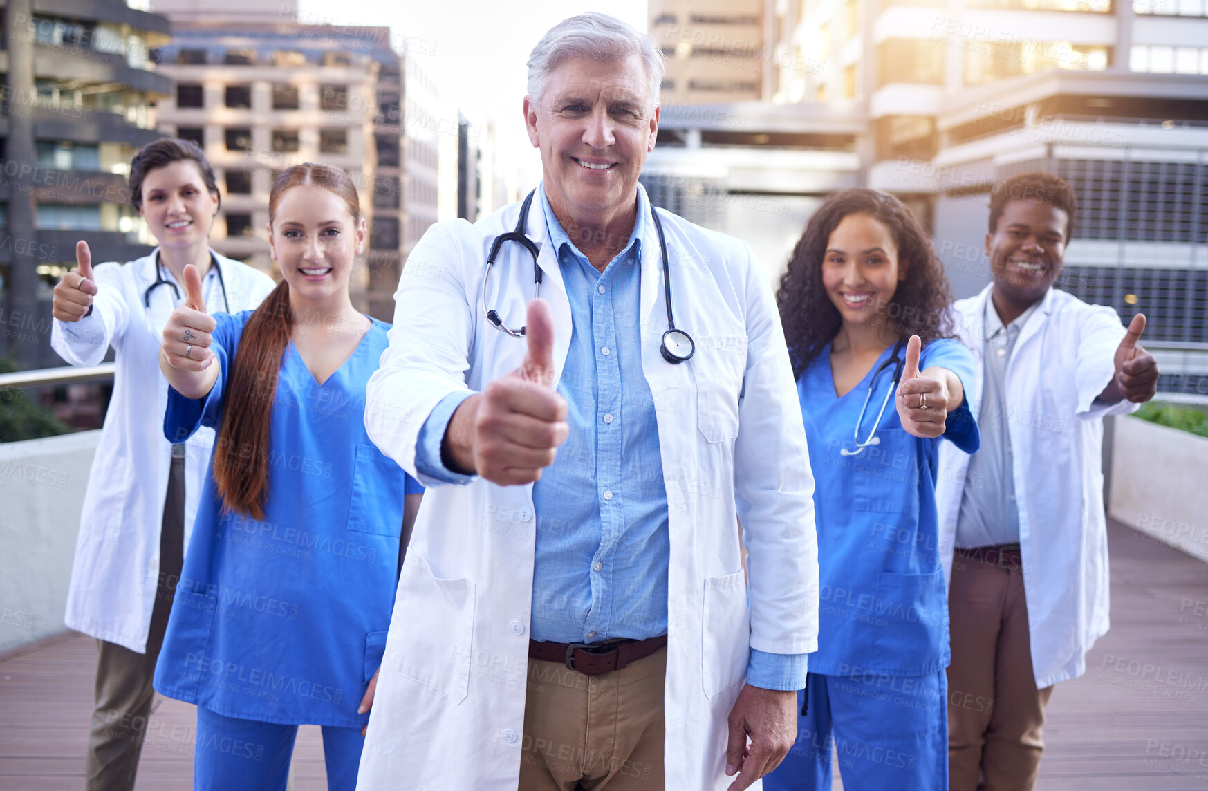 Buy stock photo Healthcare, doctor and nurse in portrait with thumbs up for motivation, agreement and great service at hospital. Diversity, success and medical people with gesture for thank you, yes or ok on balcony