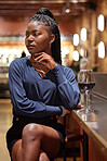 Black woman, thinking and wine on counter in restaurant, waiting for conversation, wondering and contemplating about decisions. Female person, bar thoughts and glass for drinking and daydreaming